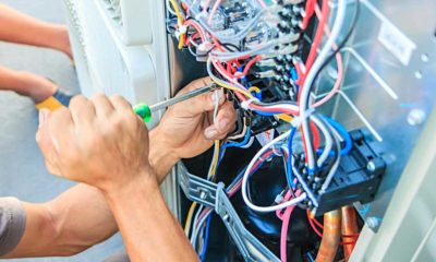 Air conditioning repair in progress with tools and wiring