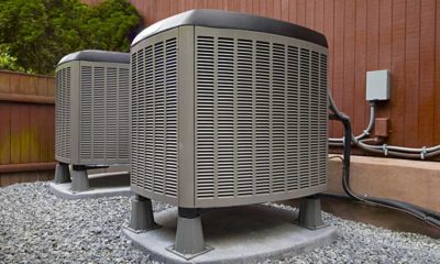 Outdoor heat pump unit being serviced by an HVAC technician